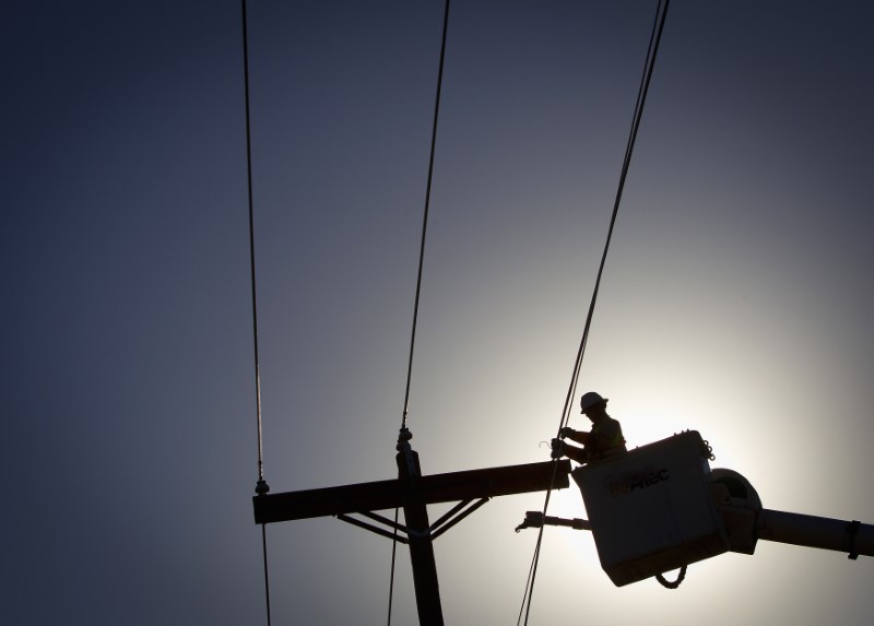 © Reuters. An electrical line technician works on restoring power in Vilonia, Arkansas