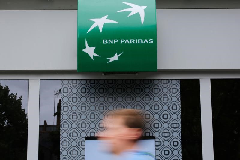 © Reuters. A man walks past a BNP Paribas bank sign on an office building in Nantes