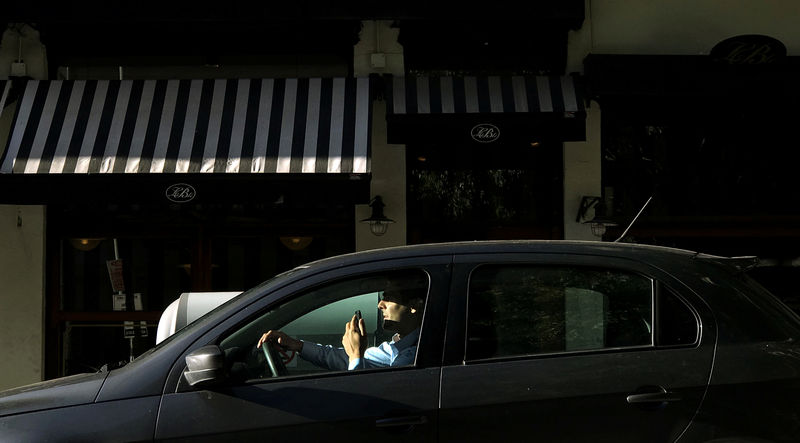 © Reuters. A man uses his mobile phone inside his car in Buenos Aires
