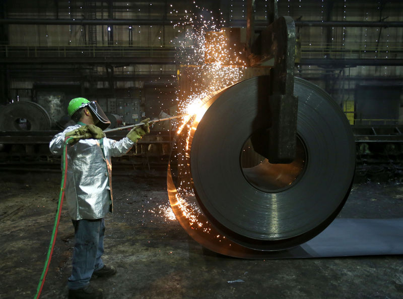 © Reuters. A worker cuts a piece from a steel coil at the Novolipetsk Steel PAO steel mill in Farrell