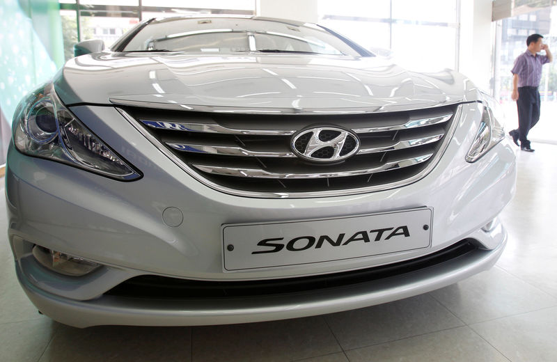 © Reuters. FILE PHOTO: An employee walks past Hyundai Motor's Sonata, on display at the automaker's dealership in Seoul