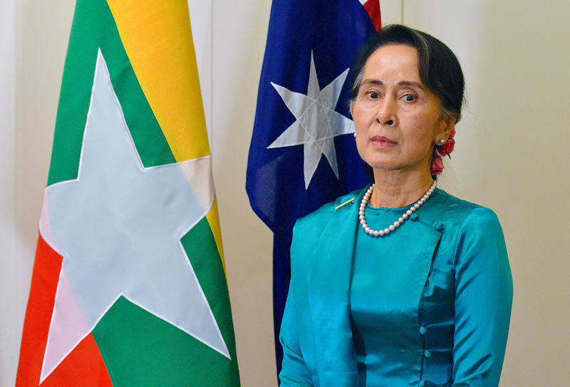 © Reuters. FILE PHOTO - Myanmar's State Counsellor Aung San Suu Kyi stands next to national flags of Australia and Myanmar at Parliament House in Canberra