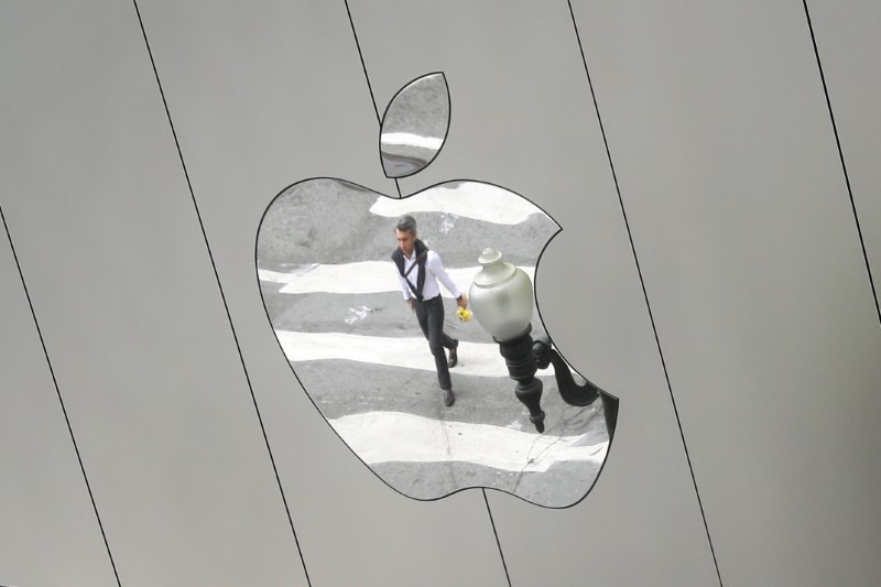 © Reuters. FILE PHOTO: A man is reflected in a Apple store logo in San Francisco