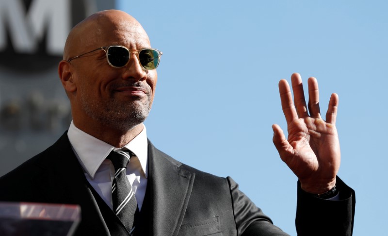 © Reuters. Ator Dwayne Johnson acena na Calçada da Fama em Los Angeles