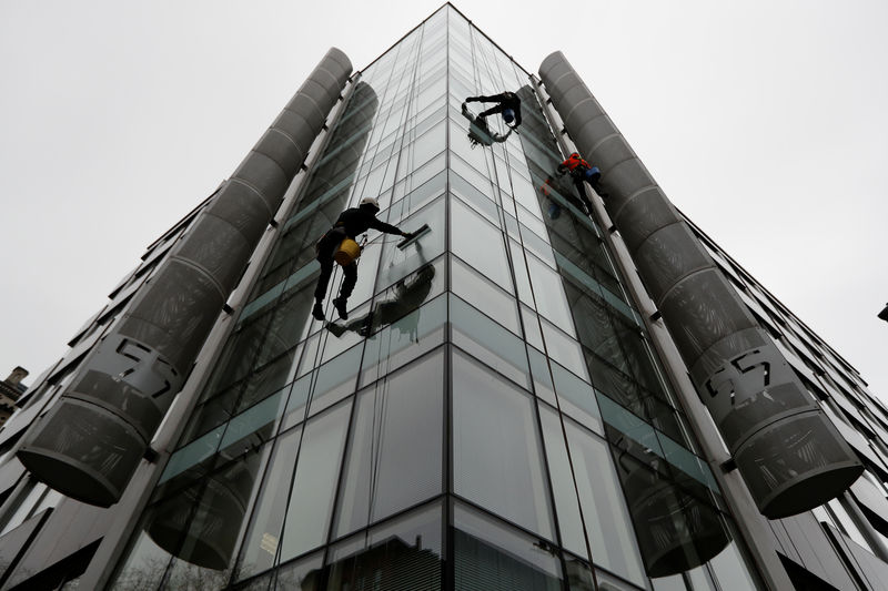 © Reuters. Limpadores de janela trabalham do lado de fora da sede da Cambridge Analytica em Londres, Reino Unido