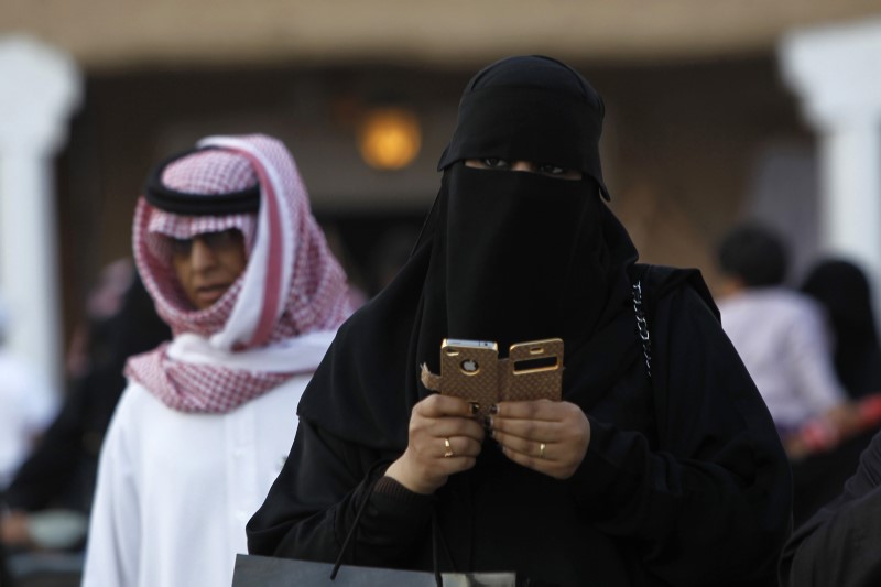 © Reuters. Mulher olha celular nas redondezas de Riad, Arábia Saudita