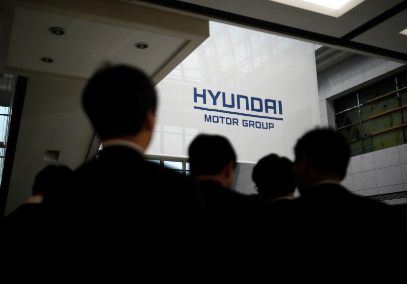 © Reuters. Employees of Hyundai Motor walk past the company's logo after the company's New Year ceremony in Seoul