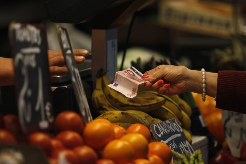 © Reuters. A customer pays with a ten-euro note to a vendor in a fruit and vegetable market in central Malaga