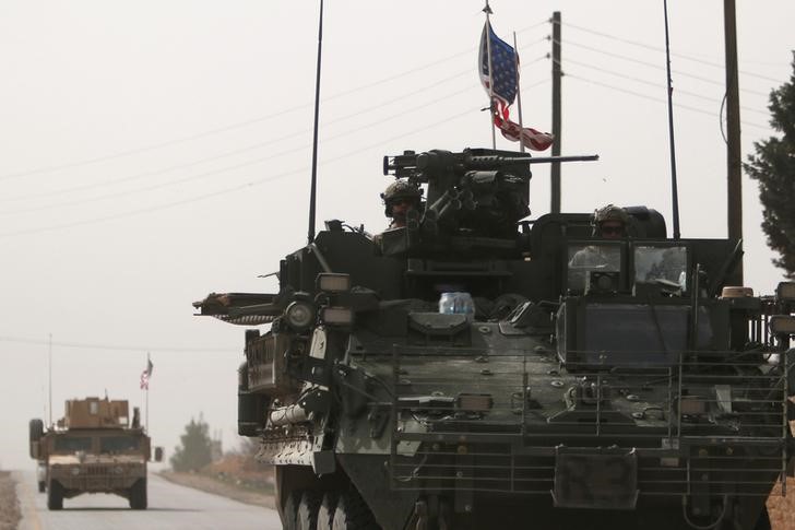 © Reuters. U.S. army vehicles drive north of Manbij city