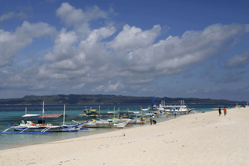 © Reuters. FILE PHOTO: Traditional boats line up the shore in a secluded beach on the island of Boracay, central Philippines