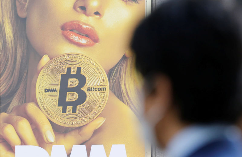 © Reuters. A man stands near an advertisement of a cryptocurrency exchange in Tokyo