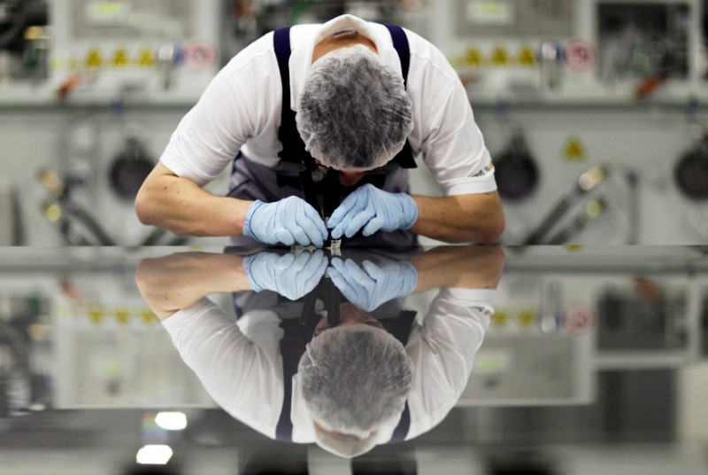 © Reuters. FILE PHOTO -  A worker of Signet Solar checks a photovoltaic module in a plant in Mochau, near Dresden