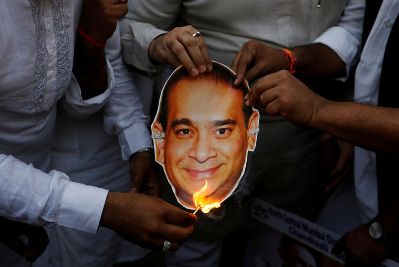 © Reuters. FILE PHOTO: Activists of the youth wing of India's main opposition Congress party burn a cut-out with an image of billionaire jeweller Nirav Modi during a protest in Mumbai