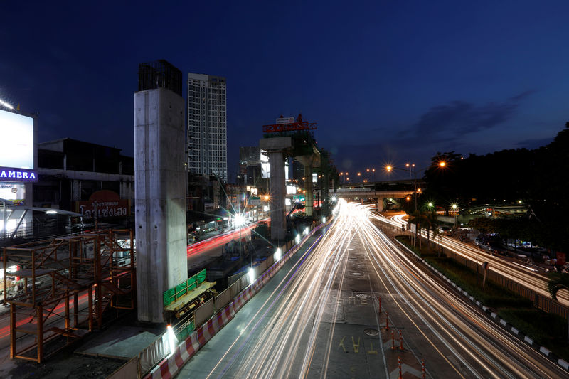 © Reuters. Cars pass Skytrain construction site in Bangkok