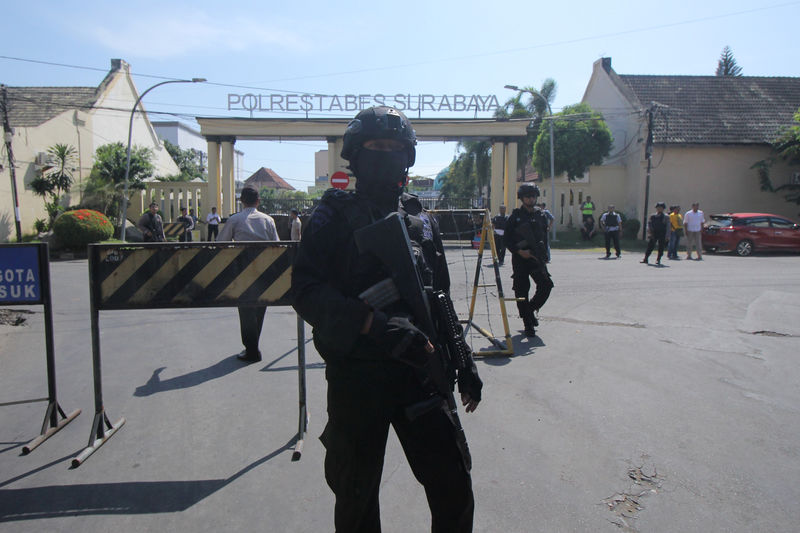 © Reuters. Police stand guard at police headquarters following a suicide attack in Surabaya