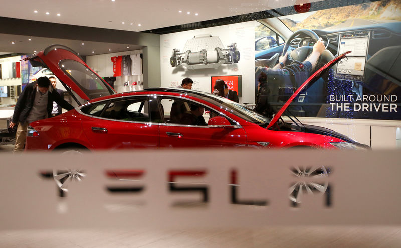 © Reuters. FILE PHOTO: A man looks around Tesla Motors' Model S P85 at its showroom in Beijing