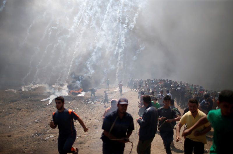 © Reuters. Manifestantes palestinas correm de gás lacrimogêneo lançado por forças israelenses na fronteira entre Gaza e Israel