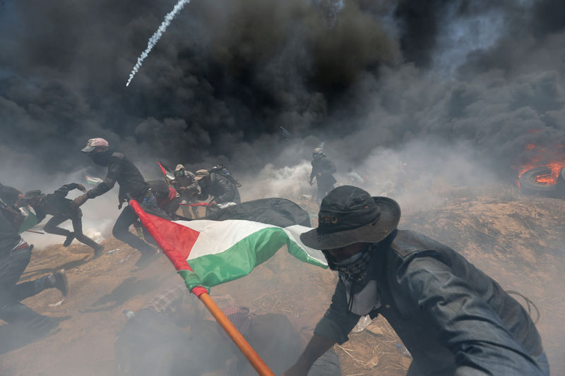 © Reuters. Manifestantes palestinios huyen de disparos y gases de fuerzas isaraelíes durante una protesta contra la instalación de la embajada de Estados Unidos, en la franja de Gaza.