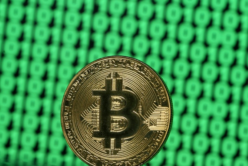 © Reuters. FILE PHOTO: Bitcoin token is seen placed on a monitor that displays binary digits in this illustration picture