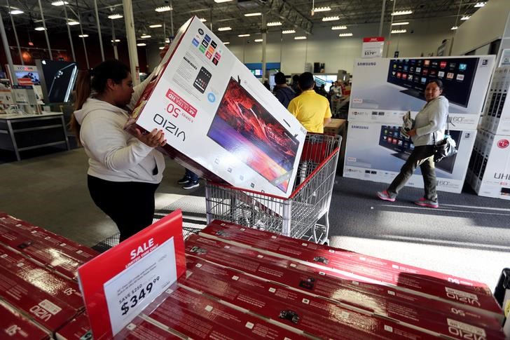 © Reuters. A woman puts a television product in her cart during Black Friday sales at a Best Buy store in Los Angeles