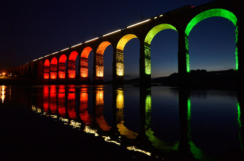 © Reuters. FILE PHOTO: A train travelling on the East Coast mainline is reflected in the River Tweed as it crosses the Royal Border Bridge at dusk, in Berwick-Upon-Tweed in Northumberland