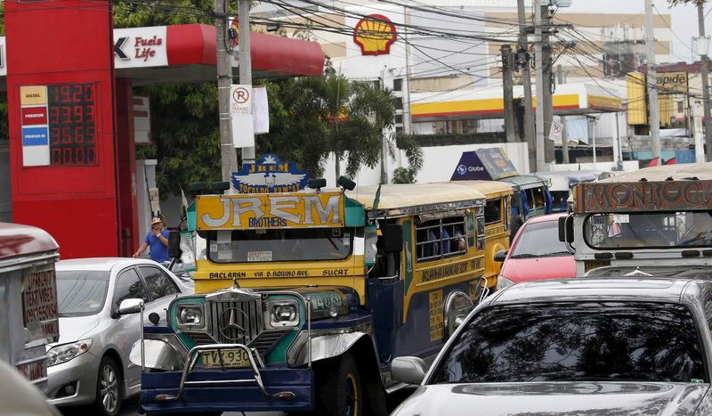 © Reuters. FILE PHOTO: Motorists drives past an electronic board at a gas station in Paranaque city