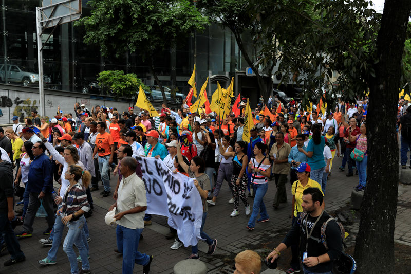 © Reuters. Manifestantes de la oposición participan en una marcha contra las próximas elecciones presidenciales en Caracas