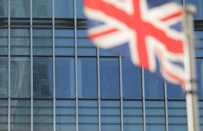 © Reuters. FILE PHOTO: A man looks from a building in the financial district of Canary Wharf
