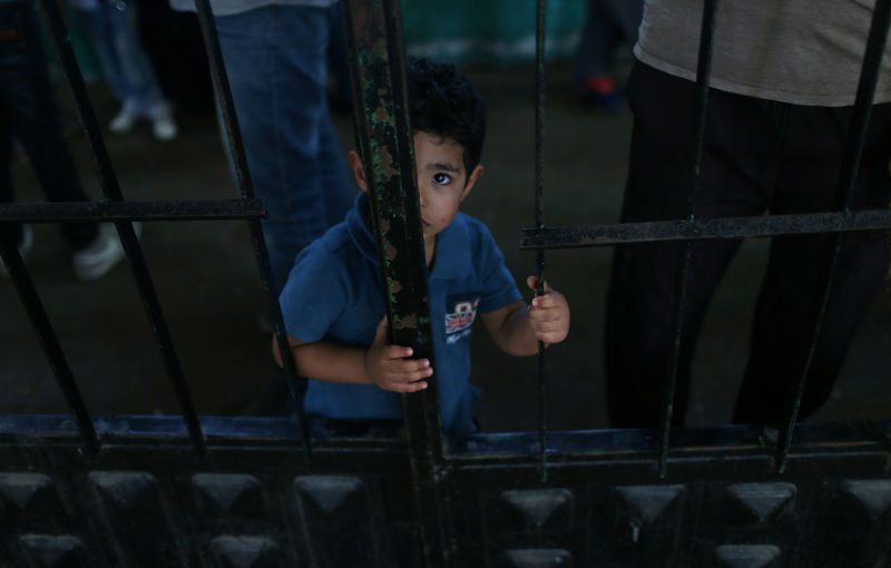 © Reuters. Menino palestino espera para viajar ao Egito pela travessia de fronteira de Rafah, na Faixa de Gaza