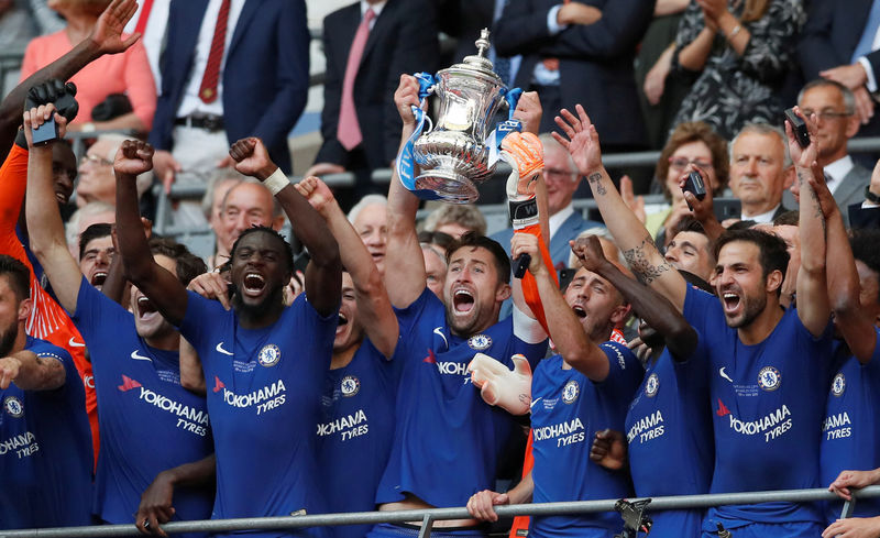 © Reuters. El capitán del Chelsea, Gary Cahill, levanta el trofeo mientras sus compañeros celebran tras ganar la final de la Copa FA.