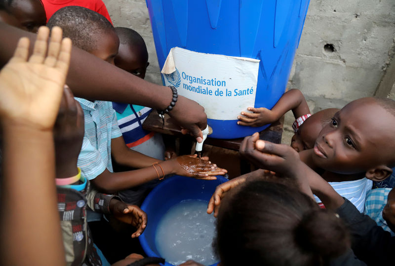 © Reuters. FILE PHOTO: Congolese children wash their hands as a preventive measure against Ebola at the Church of Christ in Mbandaka