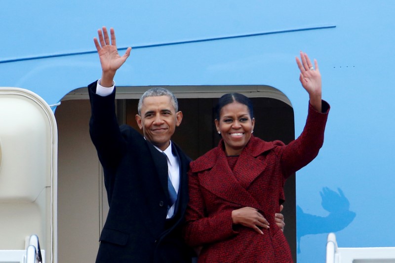 © Reuters. FILE PHOTO - Former President Barack Obama waves with his wife Michelle as they board a Boeing 747 at Joint Base Andrews