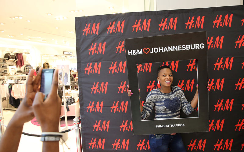 © Reuters. FILE PHOTO:  A customer is photographed outside the H&M shop at a mall in Midrand outside Johannesburg
