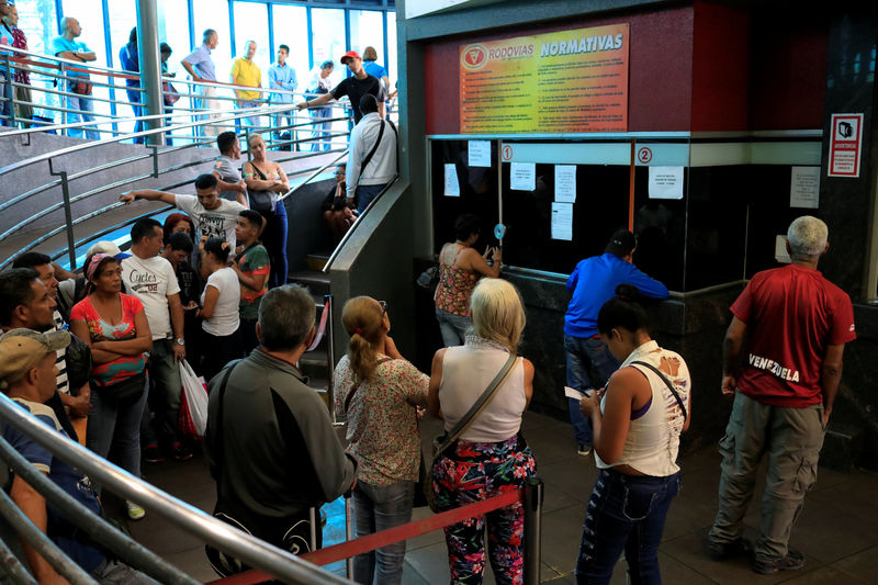 © Reuters. People wait in line to buy bus tickets at a bus station in Caracas