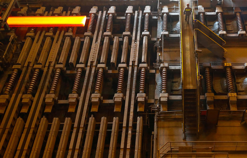 © Reuters. A red-hot steel plate passes through a press at the ArcelorMittal steel plant in Ghent