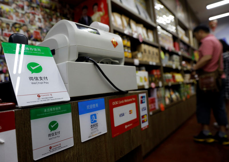 © Reuters. Signs accepting WeChat Pay and AliPay are displayed at a shop in Singapore