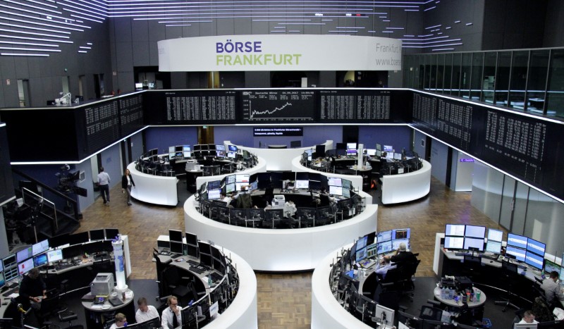 © Reuters. Traders work in front of the German share price index, DAX board, at the stock exchange in Frankfurt