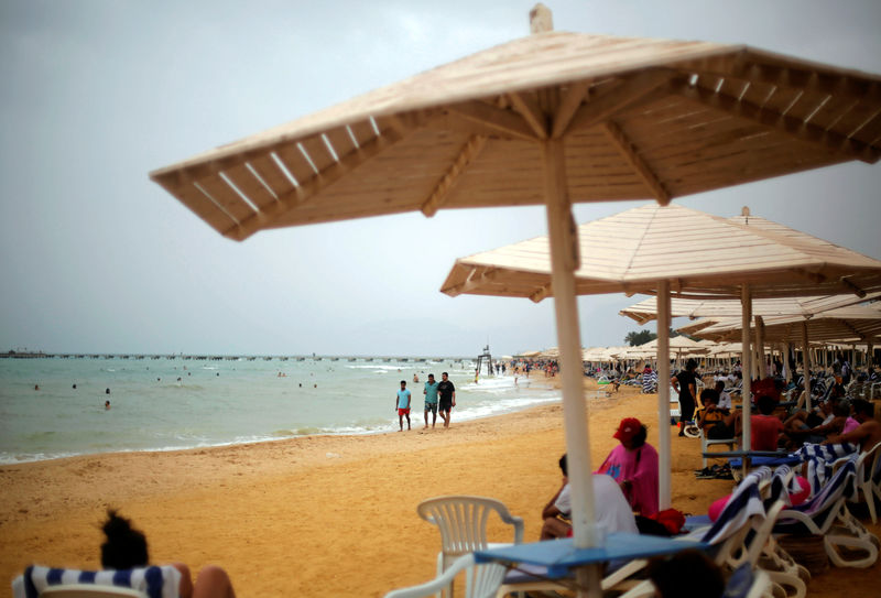 © Reuters. People enjoy on a beach at the Red Sea resort of El Ain El Sokhna in Suez, east of Cairo
