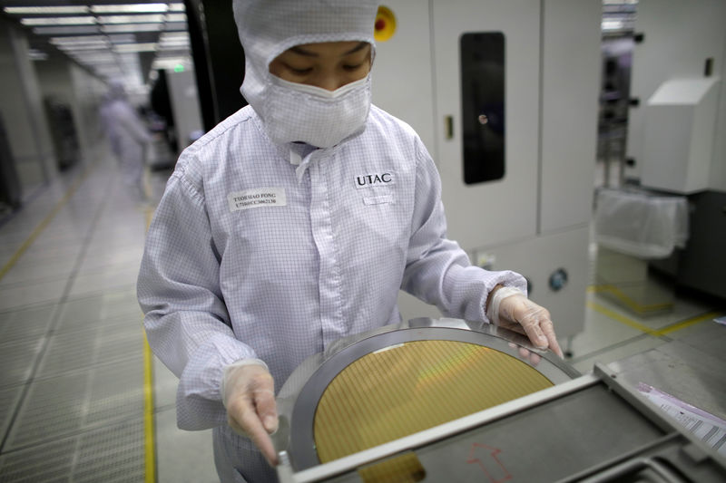 © Reuters. FILE PHOTO: A worker checks a wafer chip at the UTAC plant in Singapore