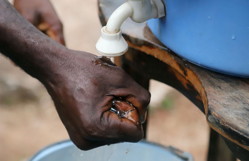 © Reuters. A Congolese man washes his hands as a preventive measure against Ebola in Mbandaka