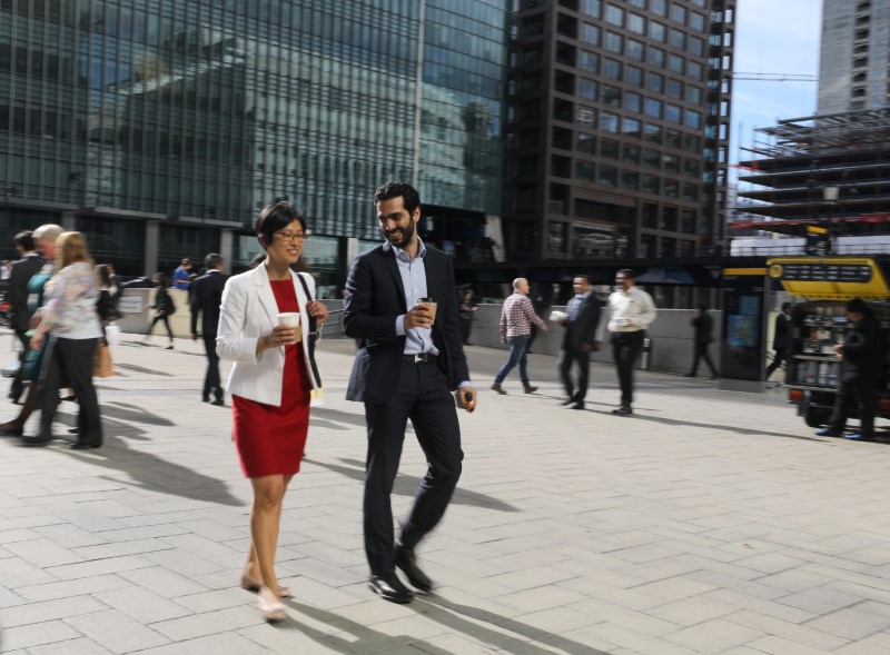 © Reuters. People walk through the financial district of Canary Wharf, London 28 September 2017.