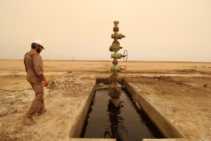 © Reuters. A worker walks past the oil well at the Sindbad oil field near the Iraqi-Iranian border in Basra