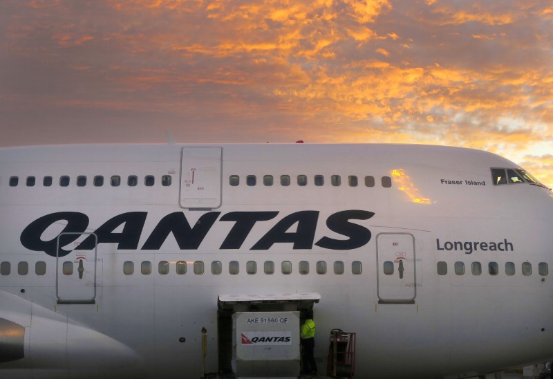 © Reuters. FILE PHOTO -  A worker unloads a Qantas Airways Boeing 747 at Sydney's International airport in Australia