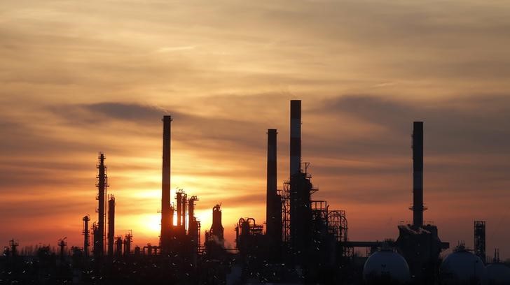 © Reuters. The sun sets behind the chimneys of the Total Grandpuits oil refinery southeast of Paris