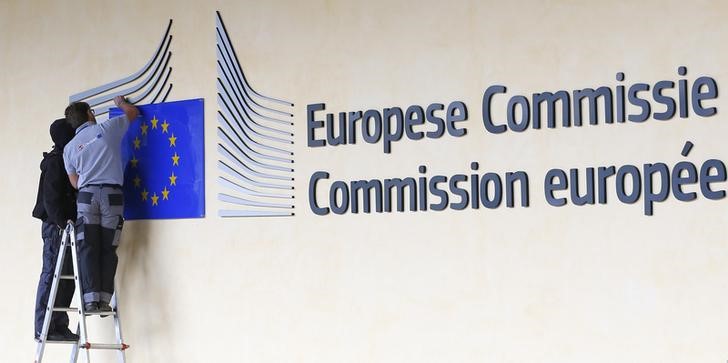 © Reuters. Worker adjust and clean the logo of the European Commission at the entrance of the EC headquarters in Brussels