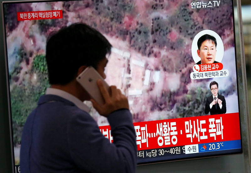 © Reuters. Homem passa por televisão transmitindo reportagem sobre destruição de instalação de testes nucleares norte-coreana em Seul, Coreia do Sul