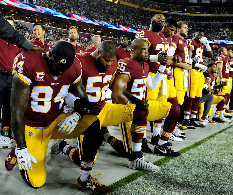 © Reuters. FILE PHOTO: Washington Redskins players kneel during the playing of the national anthem