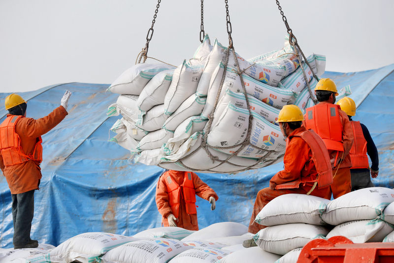 © Reuters. FILE PHOTO: Workers transport imported soybean products at a port in Nantong, Jiangsu