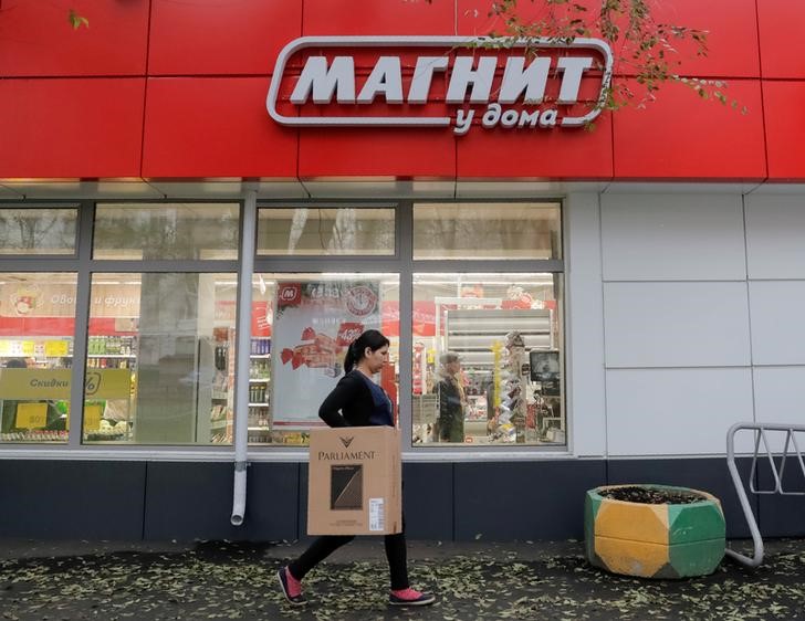 © Reuters. FILE PHOTO: A woman walks past a grocery store owned by Russian retailer Magnit in Moscow