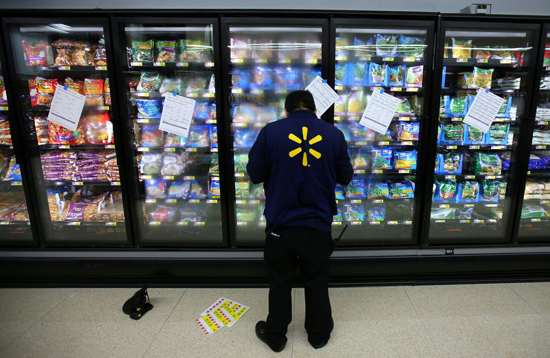 © Reuters. FILE PHOTO: A worker prepares the frozen food section at a newly built Walmart Super Center in Compton, California